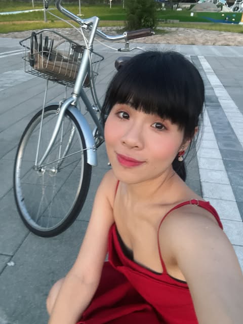 林藝穿紅色洋裝、身後停著腳踏車的生活照